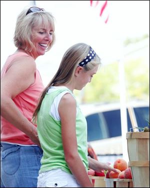 The Blade / Amy E. Voigt          Slug: NBRS PBURGMARKET30P Date:   8/23/2007                             Location: Perrysburg, Ohio CAPTION: Carol Hoffman, left, smiles at her daughter Jennifer Hoffman, right, as she looks at the peaches at the Farmers Market in Perrysburg on August 23, 2007. The market opens at 3 p.m. every Thursday through Oct. 18.