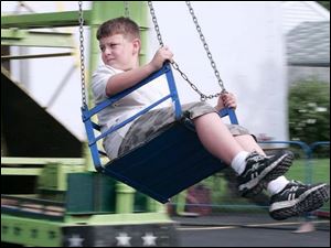 Zachary Schreiber, 11, of Grand Rapids takes a view of festival activities from a seat on one of the amusement rides.
