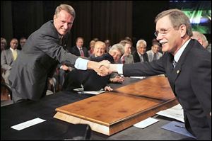 United Auto Workers President Ron Gettelfinger, right, and General Motors Chairman and CEO Rick Wagoner shake hands to open their contract talks at the UAW/GM Center for Human Resources in Detroit, in this July 23, 2007 file photo.