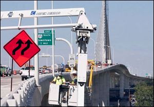 Ohio Department of Transportation employees Matt Beedy, left, and Todd Bender inspect a portion of the underside of the span.