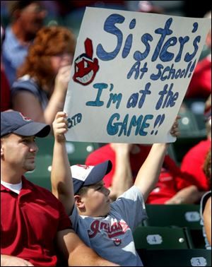 Indians fan Todd Callen Jr. rubs in his good luck to his sibling as he watches his heroes sweep the Tigers on Wednesday.