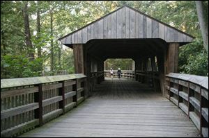 Wildwood Preserve Metropark in Toledo gained this 60-foot Howe truss covered footbridge over the Ottawa River in 2002, linking original and new sections of the park.