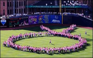 Cancer survivors form a pink ribbon at Fifth Third Field. 
