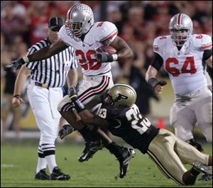 Ohio State running back Chris Wells tries to pull away from Purdue's Justin Scott in the first quarter last night. Wells gained 85 yards on 18 carries as the Buckeyes dealt the Boilermakers their first loss of the season.