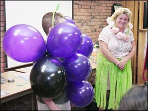 McKinney, right, of Oregon and in hula outfit, checks on the progress of "a bunch of grapes", a costume made with balloons and safety pins.