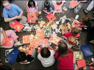 Participants decorate trick-or-treat bags with bags and materials supplied by the library.
