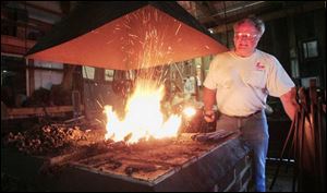 Bob Willman heats up an iron pole in his forging barn in Bowling Green.
