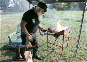  Ron Loveland of Ida, Mich., heats a steel rod during the Northwest Ohio Blacksmiths open forge meeting.