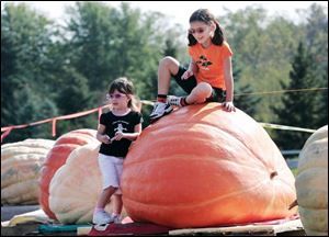 Emma Smith, 3, left, and her sister Abbey Smith, 7, of Flatrock, Mich., check out some of the large pumpkins during the 13th annual Great Pumpkin Weigh-Off at Harnica Kids' Pumpkin Farm in Dundee, Mich., on Saturday, October 6, 2007.  The event is sponsored by the Great Pumpkin Commonwealth Association.  