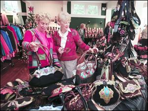Suzanne Bond of Holland, from left, and Cindy Meloy of Perrysburg look over Vietnamese-made handbags. 