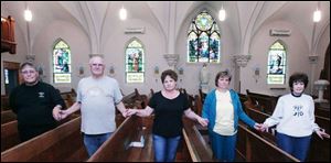 Leo Sholl, left , Gene Weidenhamer, Sue Brown, Deedi Miller, and Janet Sholl band together to stop the removal of the stained-glass windows at St. Mary Catholic Church in Junction, Ohio.