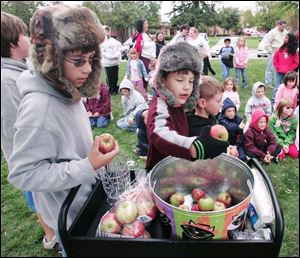 Brothers Austin Taylor, 11, and Evan, 8, choose apples to drop into the press.