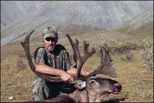 Larry Shriner of Waterville holds the rack of antlers on a huge bull caribou he bagged on a trip to Alaska with his son Mike.