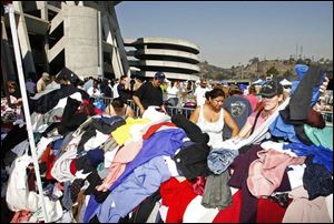 People displaced by the fires search through piles of donated clothing outside Qualcomm Stadium in San Diego. Thousands of evacuees took shelter at the stadium, home of the NFL s San Diego Chargers.
