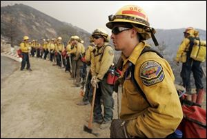 Adam Castillo and other members of the Orange County Fire Authority Strike Team prepare to move out to cut fire breaks in Live Oak Canyon in eastern Orange County, Calif. on Wednesday. 