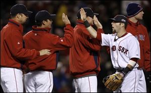 Boston Red Sox second baseman Dustin Pedroia, second left, is congratulated by his teammates after their 13-1 victory over the Colorado Rockies in Game 1 of the baseball World Series Wednesday, Oct. 24, 2007, at Fenway Park in Boston.
