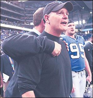 A member of the Lions' staff hugs coach Rod Marinelli during the final minutes of Detroit's game with the Broncos.