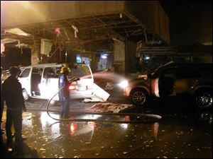 A fireman hoses down a vehicle at one of the entrances to the Philippine House of Representatives in suburban Quezon City, north of Manila, after an explosion late Tuesday Nov. 13, 2007. 