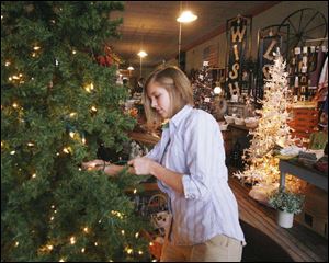 Haley Rossman of Pemberville decorates a Christmas tree in Becker's General Store.