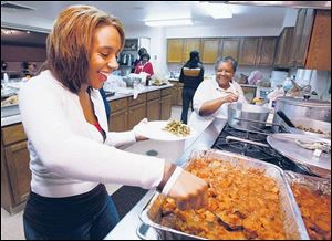Kayla Lindsey, 17, and her grandmother Gwendolyn Ellis fill plates at Warren A.M.E. Church on Collingwood Boulevard. About 20 volunteers, about half of them teenagers and children under age 12, cooked and served the holiday dinners.