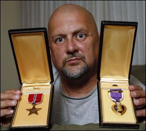 Jeff Smith displays the Bronze Star and the Purple Heart that were awarded to his brother for service in the Vietnam War.