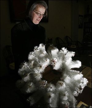 Barbara Floyd, director of the Canaday Center at the University of Toledo, holds a wreath made from fiber-glass. The center is adding more than 200 boxes of materials from the Owens Corning collection. The center already housed materials from the former Libbey-Owens-Ford and Owens-Illinois. Ms. Floyd said researchers, corporations, and collectors from around the world have sought information from the Canaday Center.