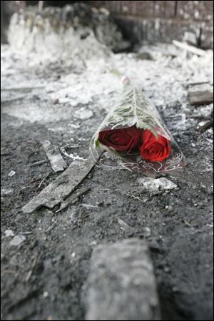 Roses are left in front of the home where four family
members died Wednesday.
