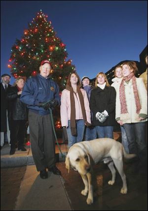 Slug:     CTY tree01p    Date:  11/30/2007        The Blade/Andy Morrison       Location:  Toledo      Caption: Mayor Carty Finkbeiner with his dog Scout, sing with members of the Toledo Central Catholic Glee club after lighting the City of Toledo Holiday Tree at One Seagate, Friday, 11/30/2007.          Summary: