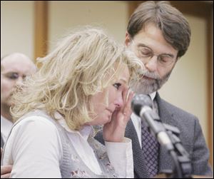 Danielle Dressel, widow of the slain police detective, is comforted by assistant Lucas County Prosecutor Dean Mandros while she makes a victim's impact statement.