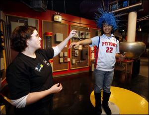 ChMarrea Parks, 10, at COSI with a Southfield, Mich., elementary, learns about static electricity with Vanessa Young.
