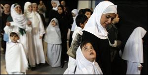 Teacher Mervat Ballut with Lila Mahmoud, 7, observe Hajj Day at Toledo Islamic Academy. 