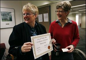 Kim Welter, left, and Merri Bame display their certificate. They arrived yesterday before Carol Bresnahan and Michelle Stecker at Government Center, but ceded their place in line.