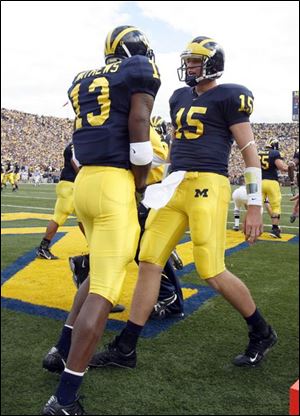 UM freshman Greg Mathews, left, celebrates a TD catch with QB Ryan Mallett, who has thrown seven this season .