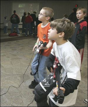 CTY light01p 1 12/31/2007   BLADE PHOTO/Lori King    Toledoan Michael Richey, 10, of Toledo, Ohio, left, and Sylvanian Max Haack, 7, compete with electric guitar during First Light at Franciscan Center in Sylvania, Ohio.
