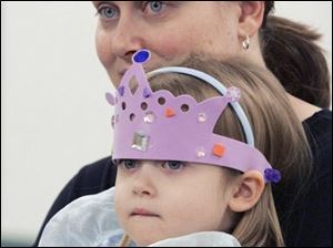 NBRN tea03 3 12/27/2007   BLADE PHOTO/Lori King    LaSalle, Mich. resident Madison Jacob, 3, is in full princess attire while listening to Monroe County queens speak during A Royal-Tea at Erie Branch library. She's sitting on her mom's (Peggy Jacob) lap.