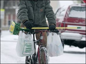 ROV snow02p 01/02/08 The Blade/Dave Zapotosky Matthew Smith bikes along snow covered Mott Ave., near East Broadway, after a trip to the store in Toledo, Ohio, on Wednesday, January 2, 2008.  He was carrying a new mop and some other cleaning supplies.