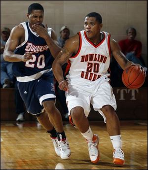 BGSU forward Nate Miller advances the ball down the court as Duquesue's Phillip Fayne defends at Anderson Arena.