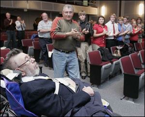 The audience at a ceremony at Rossford High School gives retired teacher Harry Wilcox a standing ovation.