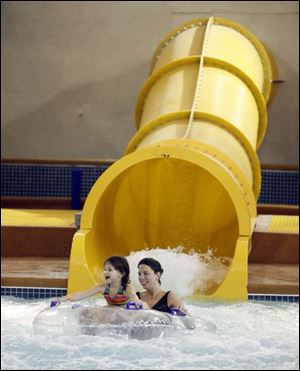 Slug:  NBR splash04p     Date: 12/29/2007         The Blade/Andy Morrison       Location:  Maumee      Caption: Samantha McDonald, 6, and her mother Debbie McDonald enjoy a water slide at Holiday Inn Splash Bay Resort. The Raleigh, North Carolina family was visiting relatives and having fun at the park, Saturday, 12/28/2007.       Summary: