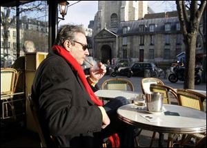 A Parisian smokes his cigar in the cold outside of Les Deux Magots, a famed Left Bank cafe that's now smoke free.