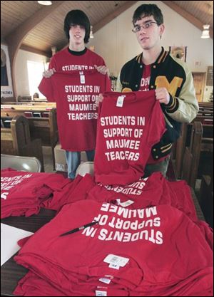 Maumee High School students Phil Beasley, left, and Nathaniel had a batch of red shirts printed that read 