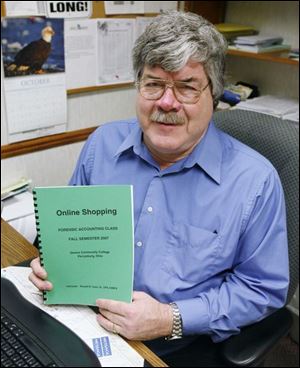 Ronald Coon, an adjunct instructor of accounting at Owens Community College, displays the guide that he and his class put together on how to avoid getting involved in Internet scams.