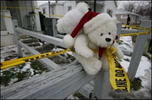 Stuffed animals were placed along the fence in front of the home along with a banner offering prayers for the family.