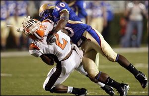 Bowling Green punt retuner Antonio Smith has his helmet knocked off after a big hit by Tulsa s Roy Roberts.
