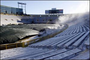 Steam escapes from the giant tarp covering the turf at Lambeau Field, where temperatures are hovering near the zero mark for today's NFC Championship as the Packers host the Giants.