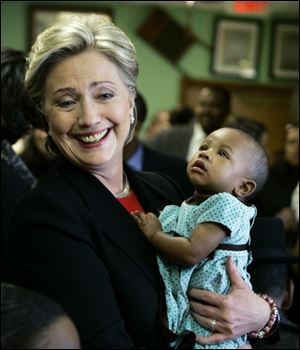 Sen. Hillary Rodham Clinton (D., N.Y.) holds 6-month-old Olevia Jones during a campaign stop at Kitchen Express in Little Rock yesterday.