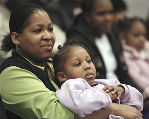 Slug: NBRW king31p B           The Blade/Jeremy Wadsworth     Date: 01/22/08                     Location: Toledo, Ohio. Caption: Talena Horton of Toledo and her daughter Trinity Enoch, 3, listen as people read excerpts from Dr. Martin Luther King Jr.'s 