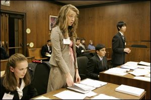Amelia Wolf, an 'attorney' for St. Ursula, standing, listens to a ruling. Seated next to her is Melissa Lenz of St. Ursula. Southview 'attorneys,' from left, are Ankit Prasad and Justin Yang.