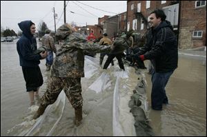 Kari Sweeney tosses a sandbag to fellow Eastwood High School student Alex Hernandez. (THE BLADE/DAVE ZAPOTOSKY)
<br>
<img src=http://www.toledoblade.com/graphics/icons/photo.gif> <b><font color=red>VIEW</b></font color=red>: <a href=