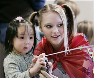 NBRN heroes07p  02/02/08  The Blade/Dave Zapotosky Caption: Keira Eby, 3, of Ida, Mich., left, fires a blast from a can of string with the help of Laurel Mavis, 13, of Petersburg, Mich., during the Superheroes Training Camp at the Ida Branch Library in Ida, Mich., on Saturday, February 2, 2008. Summary: Superheroes Training Camp at the Ida Branch Library in Ida, Mich.